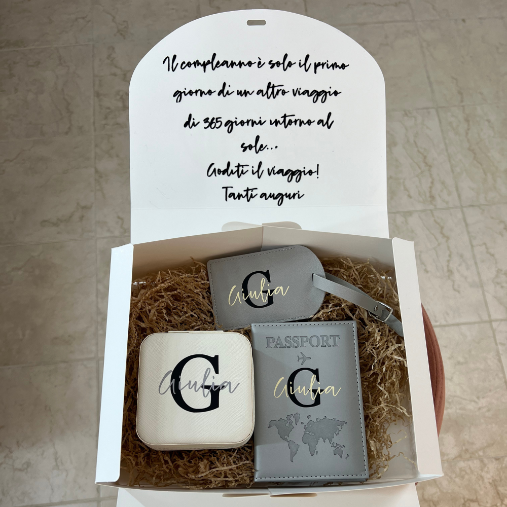 box compleanno in cartone che potrete personalizzare con nome e dedica con all'interno un porta passaporto personalizzabile, un etichetta bagaglio personalizzabile e un portagioie personalizzabile