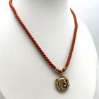 collana con cordino torchon color rosso mattone con moneta in acciaio gold